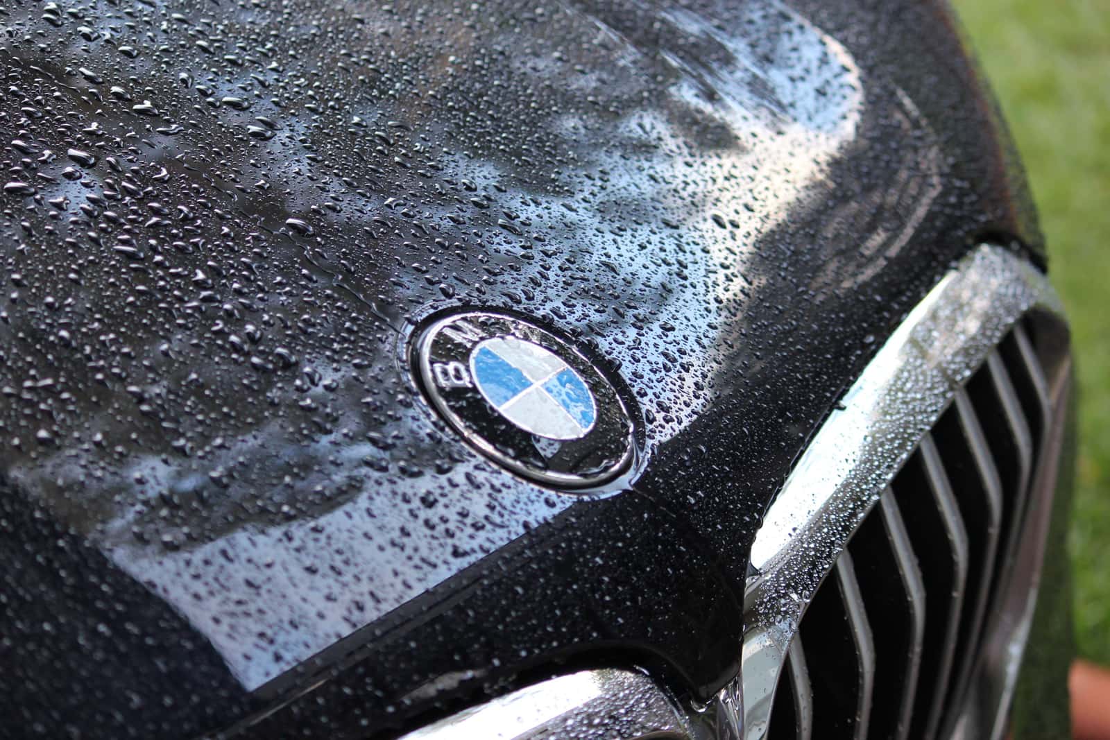 Water beading tightly on a freshly ceramic-coated gloss-black car panel